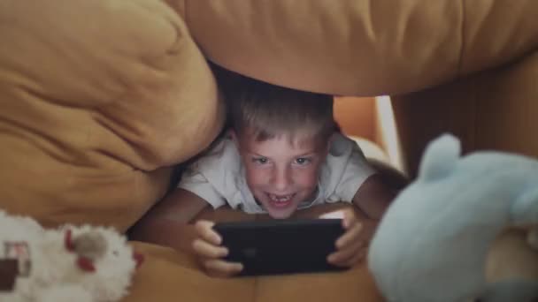 Chłopiec emocjonalnie gra w telefon komórkowy. — Wideo stockowe