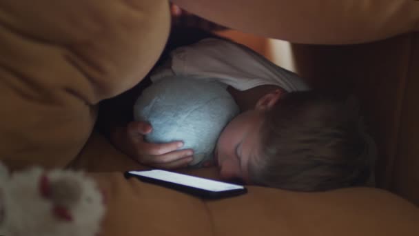 Chlapec schovaný v polštářích pohovky a usnul. — Stock video