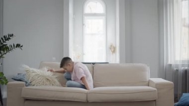 Çocuk eğleniyor. Koltuğa atlıyor..