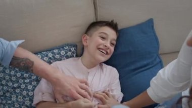 Koltukta uzanan genç bir aile. Anne, baba ve oğul. Eğleniyorlar..