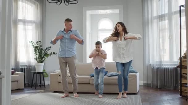 Отдых Молодая семья папа мама и сын танцуют в комнате босиком. — стоковое видео
