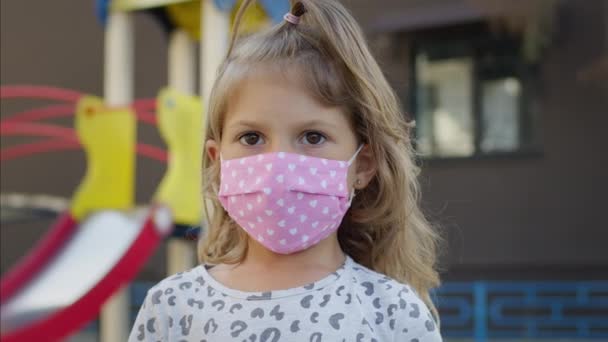 Piccola bella ragazza in maschera medica per proteggere contro l'infezione virale. — Video Stock