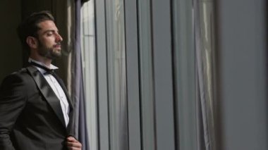 Takım Elbiseli Genç Adamın Portresi. Kendinden emin bir adamın görüntüsü. O, pencerenin yanında duruyor. Ekran Penceresinde.