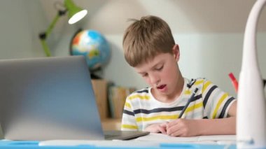 Evde dizüstü bilgisayarda oturan çocuk. Sevimli Yedi Yaşındaki Çocuk Çiziyor.