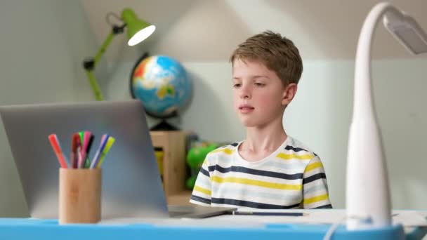 Chlapec sedí doma u laptopu. Boy Of Seven Talking Online S Učitelem. — Stock video