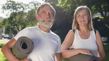 Parkta ellerinde spor minderleriyle bekleyen iki yaşlı insan. Güzel konuşuyorlar..