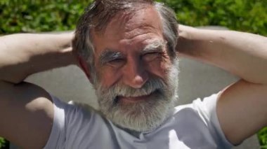 Mat 'te Çimlerde Yatan Yaşlı Adam. Egzersiz yapıyor. Sakallı Gri Adam.
