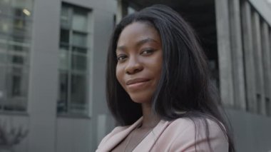 Sokakta duran güzel siyah kız. Uzun saçlı, gülümseyen güzel kız..