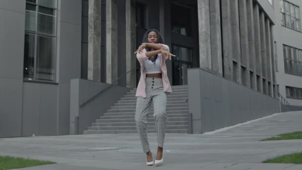 Menina em roupas de negócios dançando perto do prédio do escritório. — Vídeo de Stock