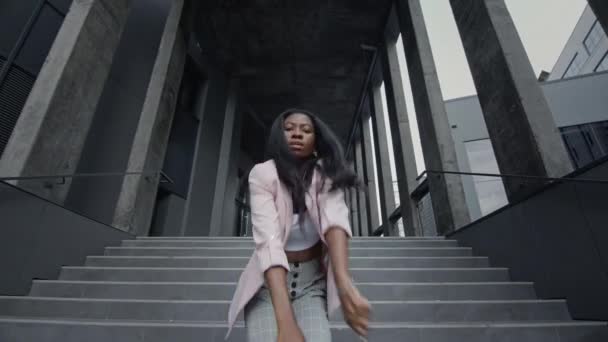 Young Black Girl Dancing Modern Dance On The Stairs (en inglés). Ella está en ropa de negocios. cámara entonces se acerca a la chica entonces se mueve lejos. — Vídeo de stock