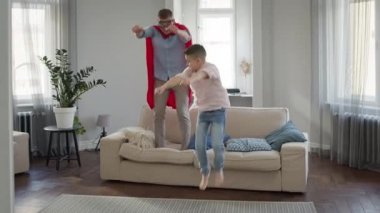 Baba ve Oğul apartmanda oyun oynuyorlar. Babam kırmızı pelerinli ve gözlüklü..