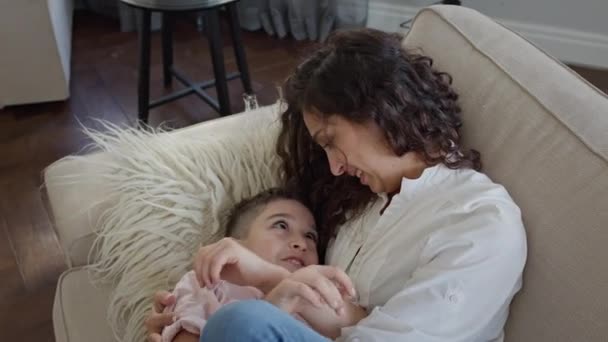 Mom And Son Lying On The Couch Hugging. Wanita muda berambut keriting panjang dan anak laki-laki delapan tahun. — Stok Video