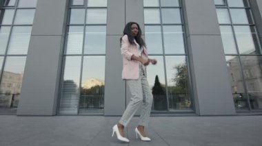 Sokakta dans eden güzel siyah kız. Uzun binalarının arkasında. Modern Danslar.