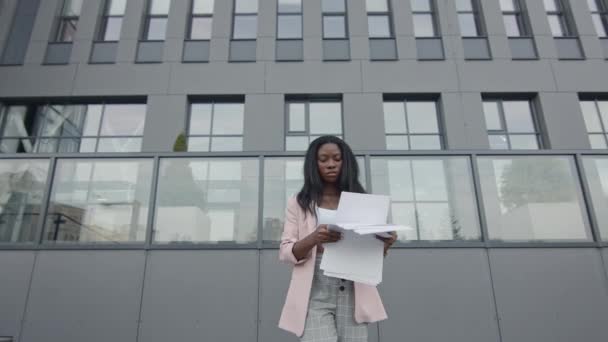 Černá holka jde po ulici. Girl In Business Clothes With Documents In Hands. Dívka začne tančit moderní tance. — Stock video