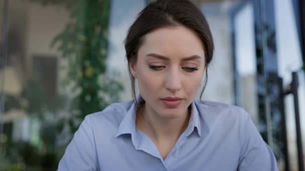 Young Girl Worker In The Office. She Is Sitting At The Table And Holding Mobile Phone In Her Hands. She Is Disappointed With The Correspondence And Sighs Heavily. — Stock Video