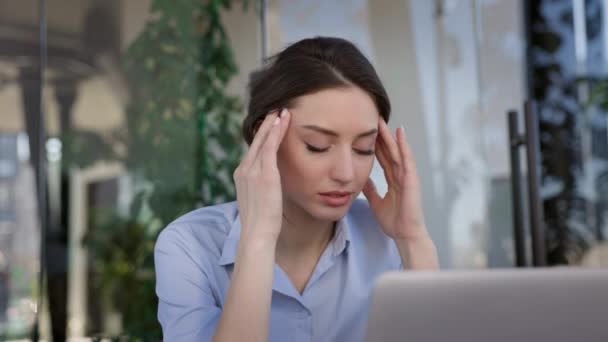 Portret van een jonge kantoormedewerker. Meisje zit aan tafel en doet tempelmassage. Ze heeft hoofdpijn.. — Stockvideo