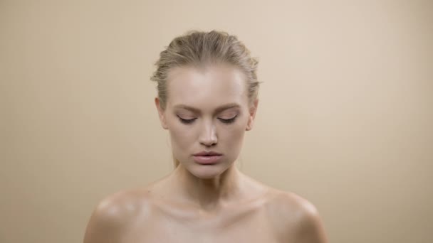 Ansiktet på snygg ung modell med vacker hud. Söt blondin höjer huvudet och tittar på kameran. — Stockvideo