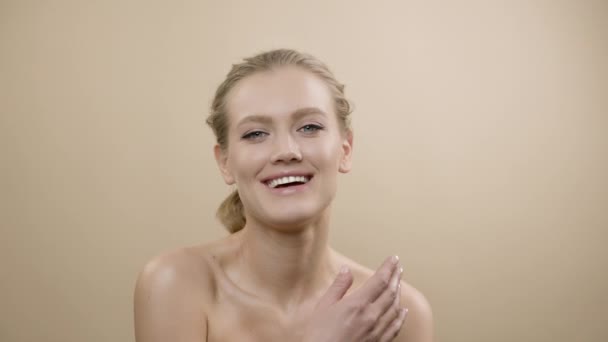 Gezicht van stijlvol jong model met mooie huid. Mooi Blond steekt haar hoofd op en kijkt naar de camera. Meisje glimlachen. — Stockvideo