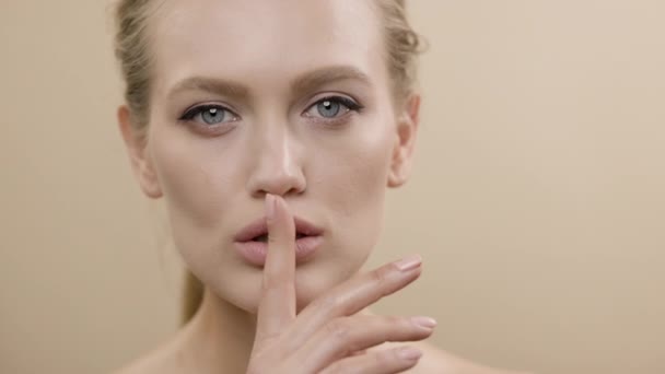 Twarz stylowej młodej modelki z piękną skórą. Dziewczyna trzyma palec na ustach, jakby gesturing Milczenie. — Wideo stockowe