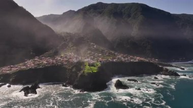 Sis ve gök gürültülü dalgalarla kaplanmış karanlık kayalıklar fırtınalı sular kıyıya vururken gri sis sarmış engebeli kayalıkları.