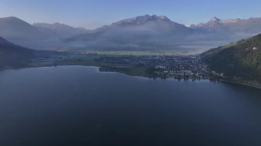 Panoramik göl ve dağlık manzara yansıtıcı sakin su ve uzak tepeler, geniş hava görüntüsü seyahat promosyonu için ideal