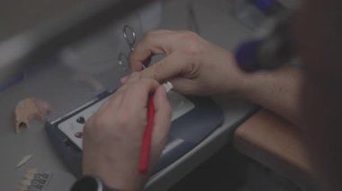 Manken tepsisindeki kırmızı kalemle kaplama kenarını işaretleyen eller, laboratuvar bankındaki hassas teftiş ve ölçüm, teknisyen