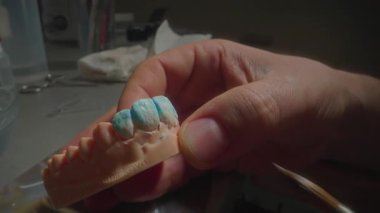 Kapalı seramik uzmanı cam ve dokuyu rafine etmek için taç yüzeyi tarıyor. Nazik vuruşlar parlatıcı ve anatomi oluşturur.