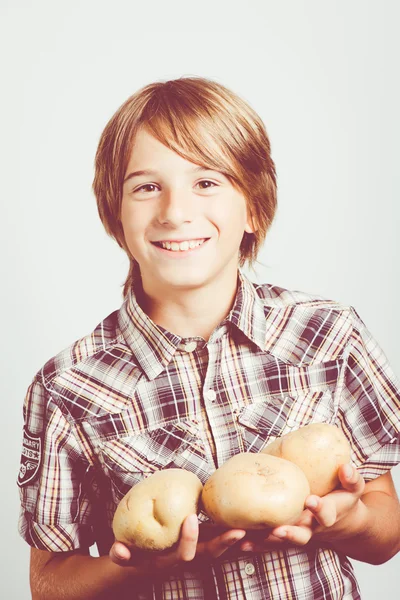 Enfant avec de grosses pommes de terre — Photo