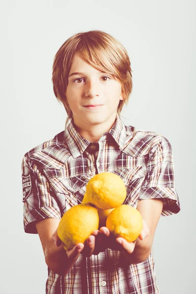 Niño con limones frescos —  Fotos de Stock