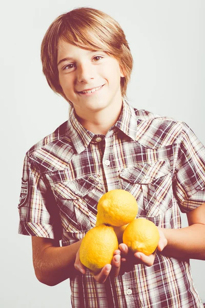 Niño con limones frescos — Foto de Stock