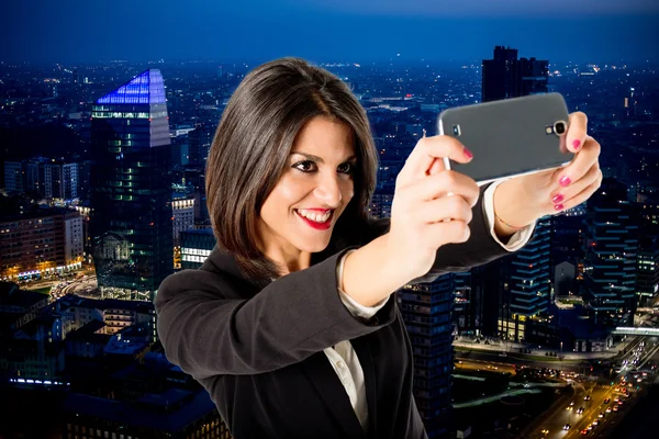 Zakenvrouw selfie van wolkenkrabber per nacht — Stockfoto