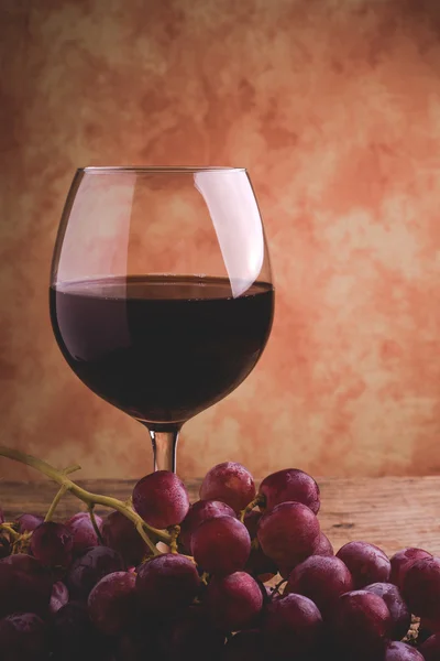 Wine glass and red grapes