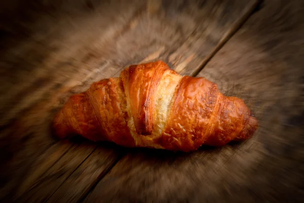 Croissant na mesa de madeira - foto de estilo borrada — Fotografia de Stock