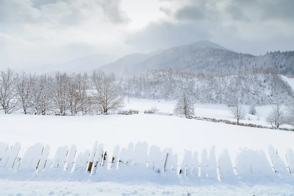 Snow fence and Caucasus Mountains — Stock Photo, Image