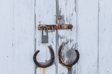 Ahır girişindeki paslı kapı mandalını yakın plan çek.