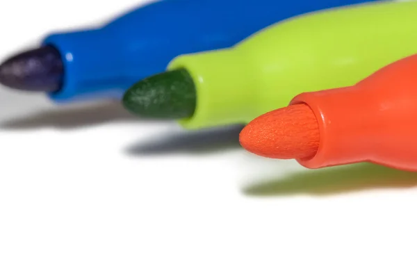 Three colorful markers on white background
