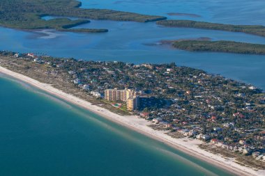 Küçük bir jet uçağından çekilen temiz su sahili manzaralı apartman ve düzenli evler..