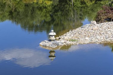 Stone lantern in middle of the lake at Japanese garden in Grand rapids clipart