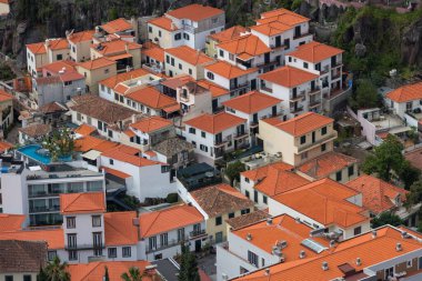 Aerial view of luxury homes with red roofs at Camara de Lobos city Harbor in Madeira Island, Portugal.