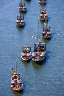 Porto, Portekiz - 22 Nisan 2024: Portekiz 'in Porto şehrinde bir Douro Nehri üzerindeki Rabelo Tekneleri adı verilen sıra sıra şarap teknelerinin havadan görünüşü.