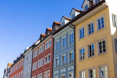 Almanya 'nın Landsberg şehrindeki renkli Bavyera tarzı apartmanlar mavi gökyüzüne karşı.