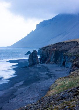 İzlanda 'nın doğu kıyısında bulunan deniz yığınları ve siyah kumsallar..