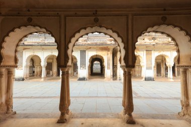 Hyderabad Hindistan 'daki tarihi bir sarayın taş avlusunu tanımlayan kemer ve kolonlar.