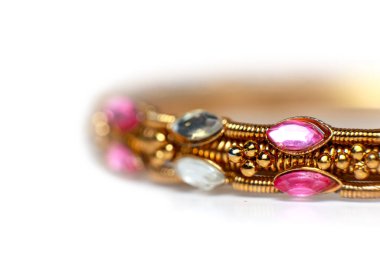 Altın bilezik parlak pembe ve berrak markiz şekilli değerli taşlar ve boncuklu detaylarla süslenmiş.