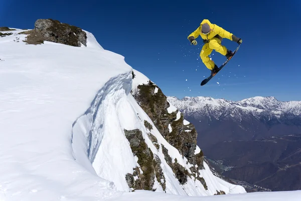 Repülő snowboardos a hegyekben. Extrém sport. — Stock Fotó