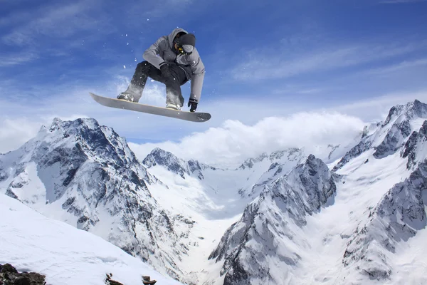 Repülő snowboardos a hegyekben. Extrém sport. — Stock Fotó