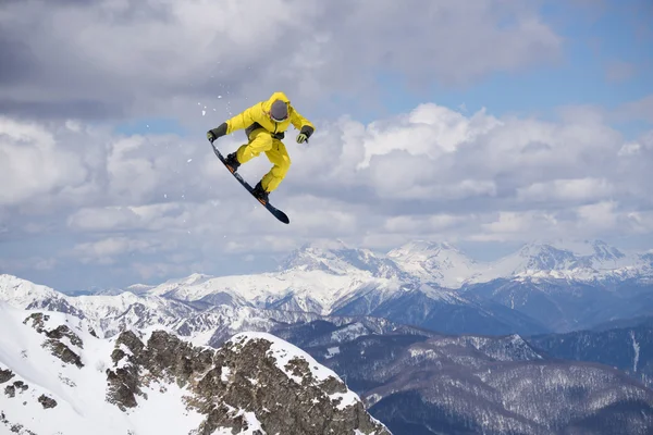 Um snowboarder voador nas montanhas. Desporto extremo. — Fotografia de Stock