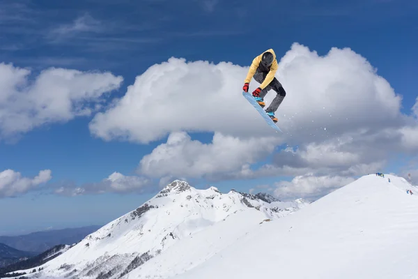 Um snowboarder voador nas montanhas. Desporto extremo. — Fotografia de Stock