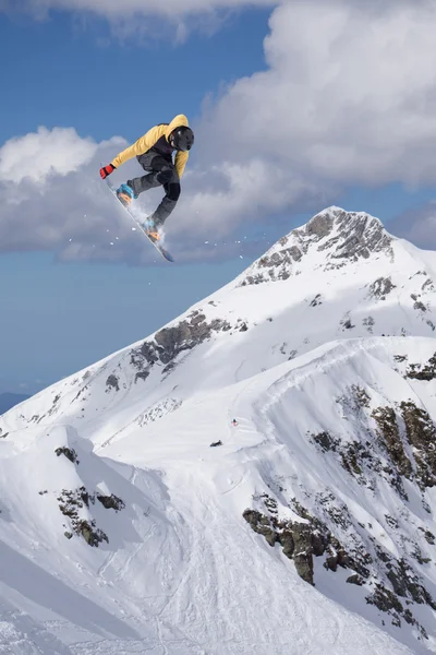 Flygande snowboardåkare på fjället. Extrem sport. — Stockfoto