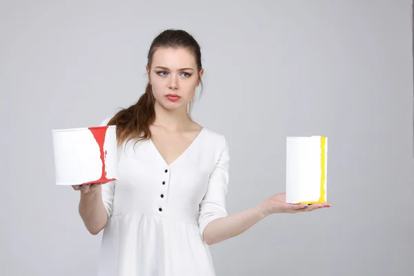 Menina de vestido branco segurando latas de tinta — Fotografia de Stock